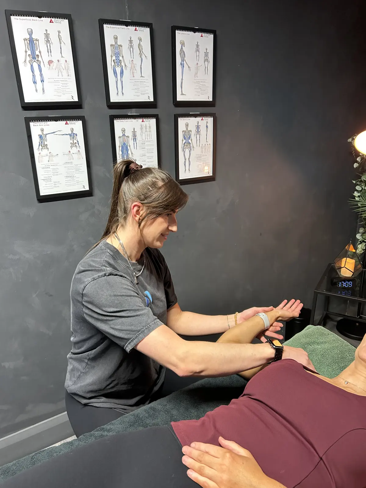 Sapphire performing a shoulder assessment during a neuromuscular therapy session at Alchemy, Ballymena